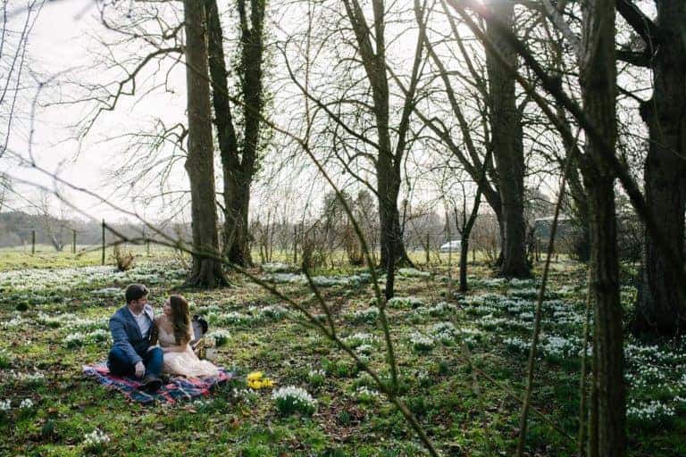 Engaged couple among the snowdrops in Elsham Hall Country Park in February