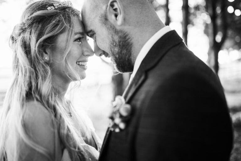 Black and white photo of the bride and groom forehead to forehead – natural, emotional couple portrait at Bunny Hill