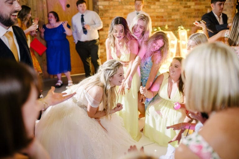 Bride and her bridesmaids dancing together at a Bunny Hill evening wedding reception