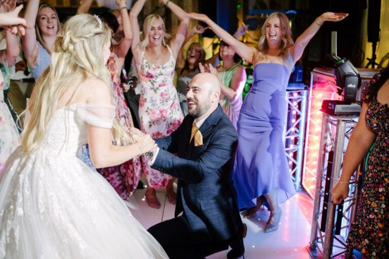 Bride and groom dancing with friends under the disco lights at Bunny Hill barn wedding venue