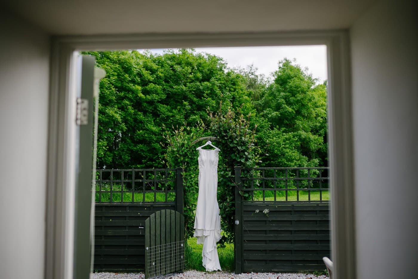 brides dress hung up for a photo at the swallows nest for oaklands bridal preparations