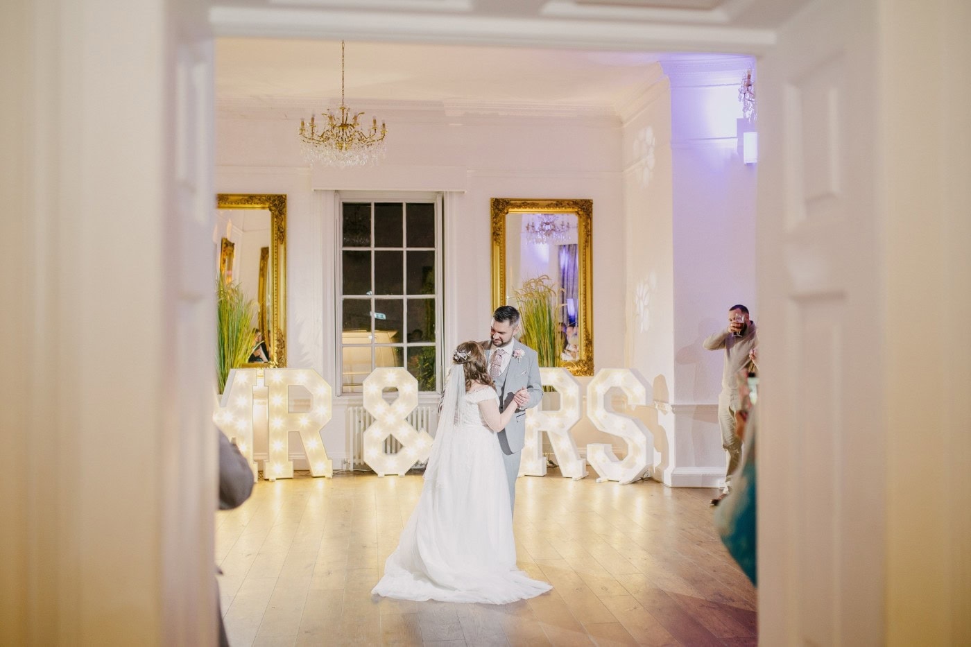 A wide view of the first dance under warm lights at Bawtry Hall, with family and friends gathered round