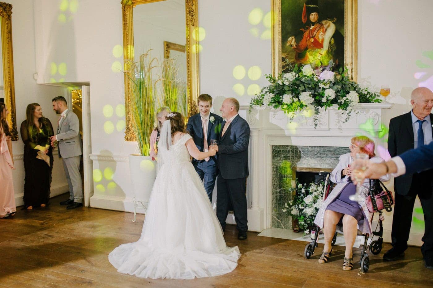 The bride dancing with a guest by the fireplace