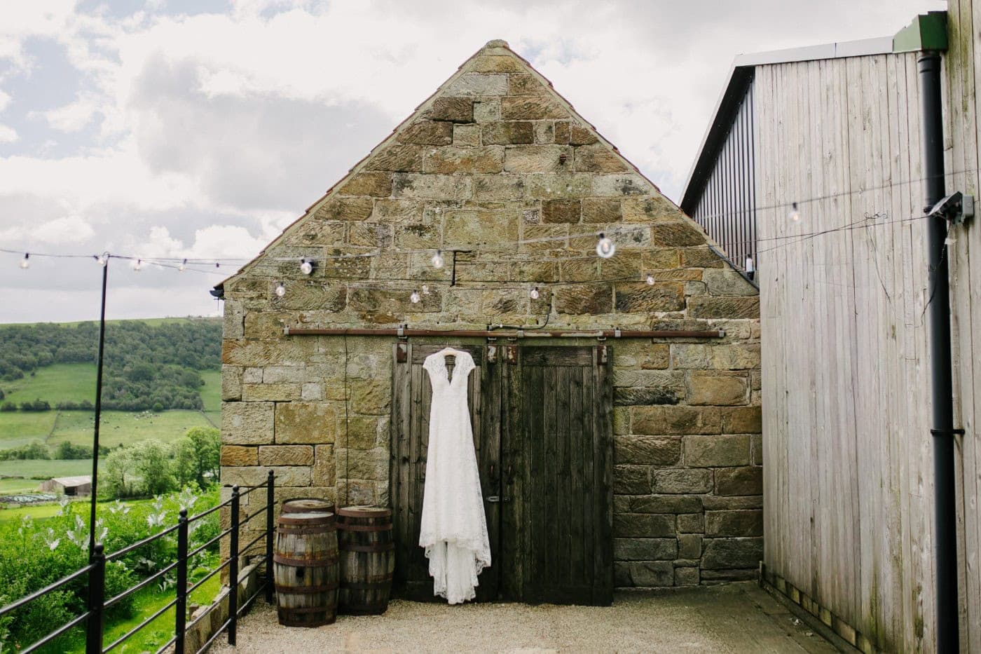 Wedding dress hanging on the door of an old stone outbuilding at Danby Castle