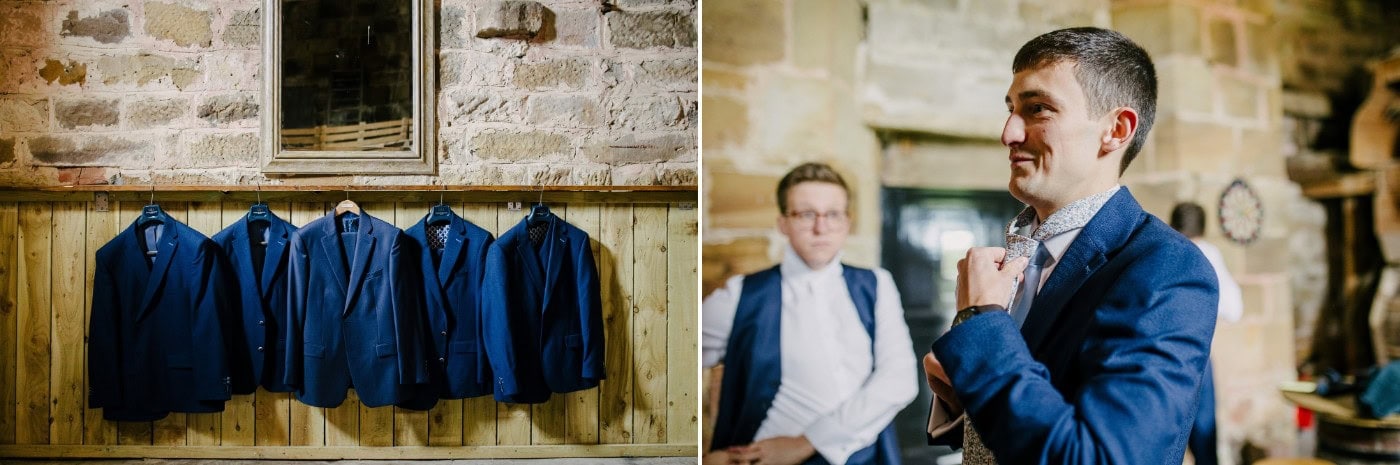 Navy suits hanging up and the groom getting ready with his groomsmen