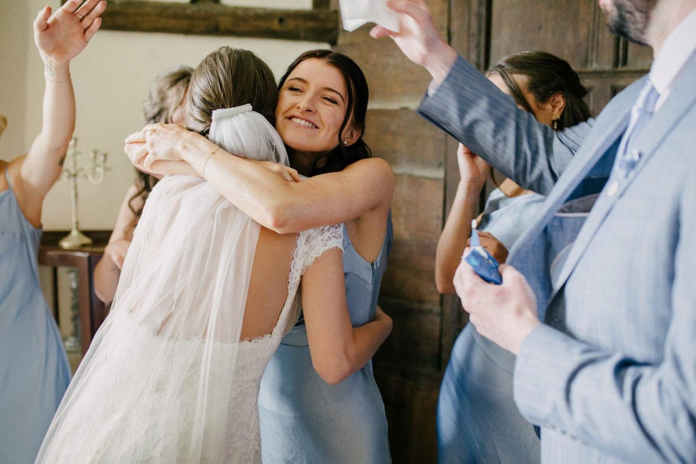 Ellie hugging her bridesmaids with happy tears after they see her in her dress