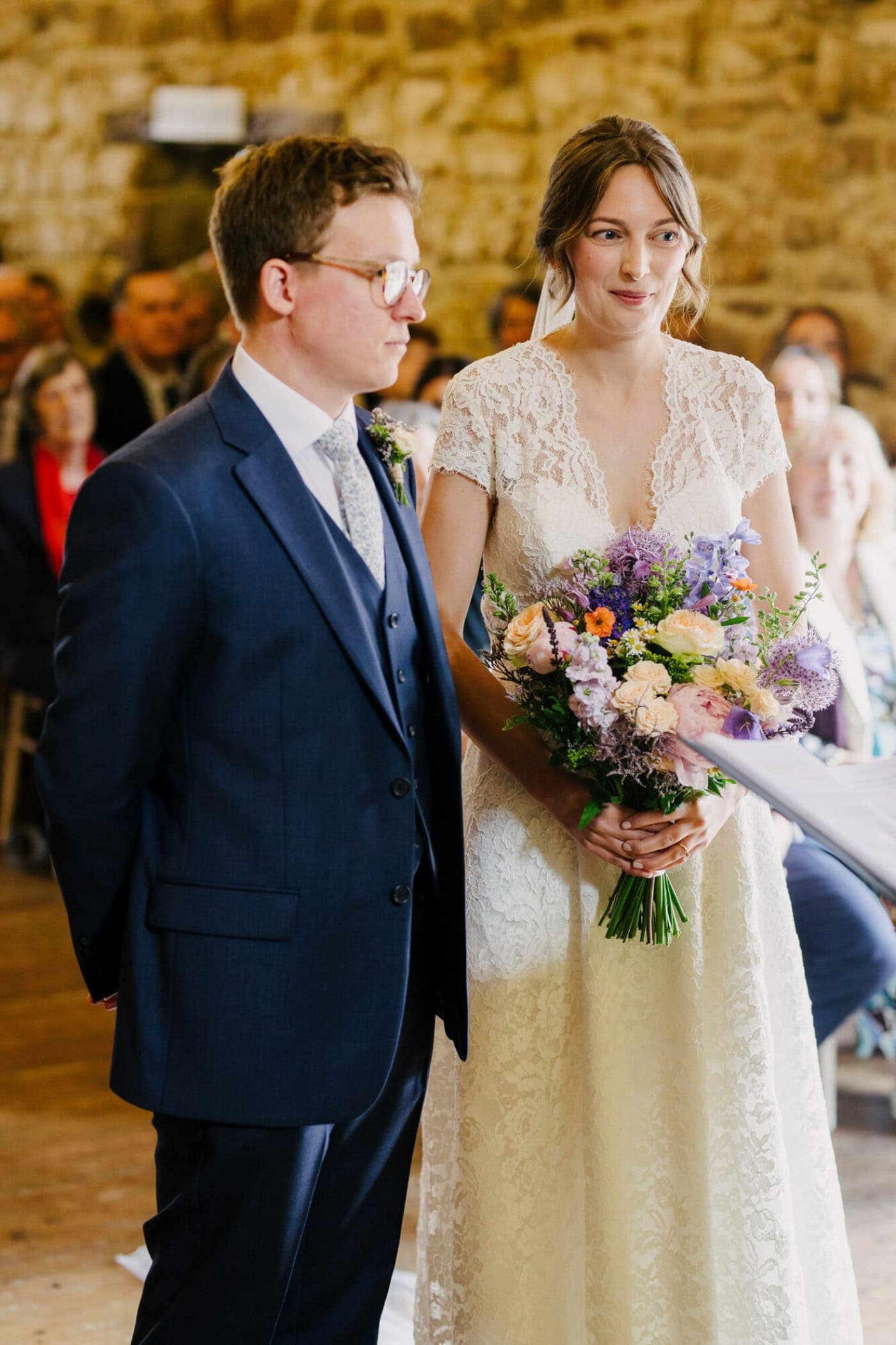 Ellie and George at the front of the ceremony under the oak beams at Danby Castle