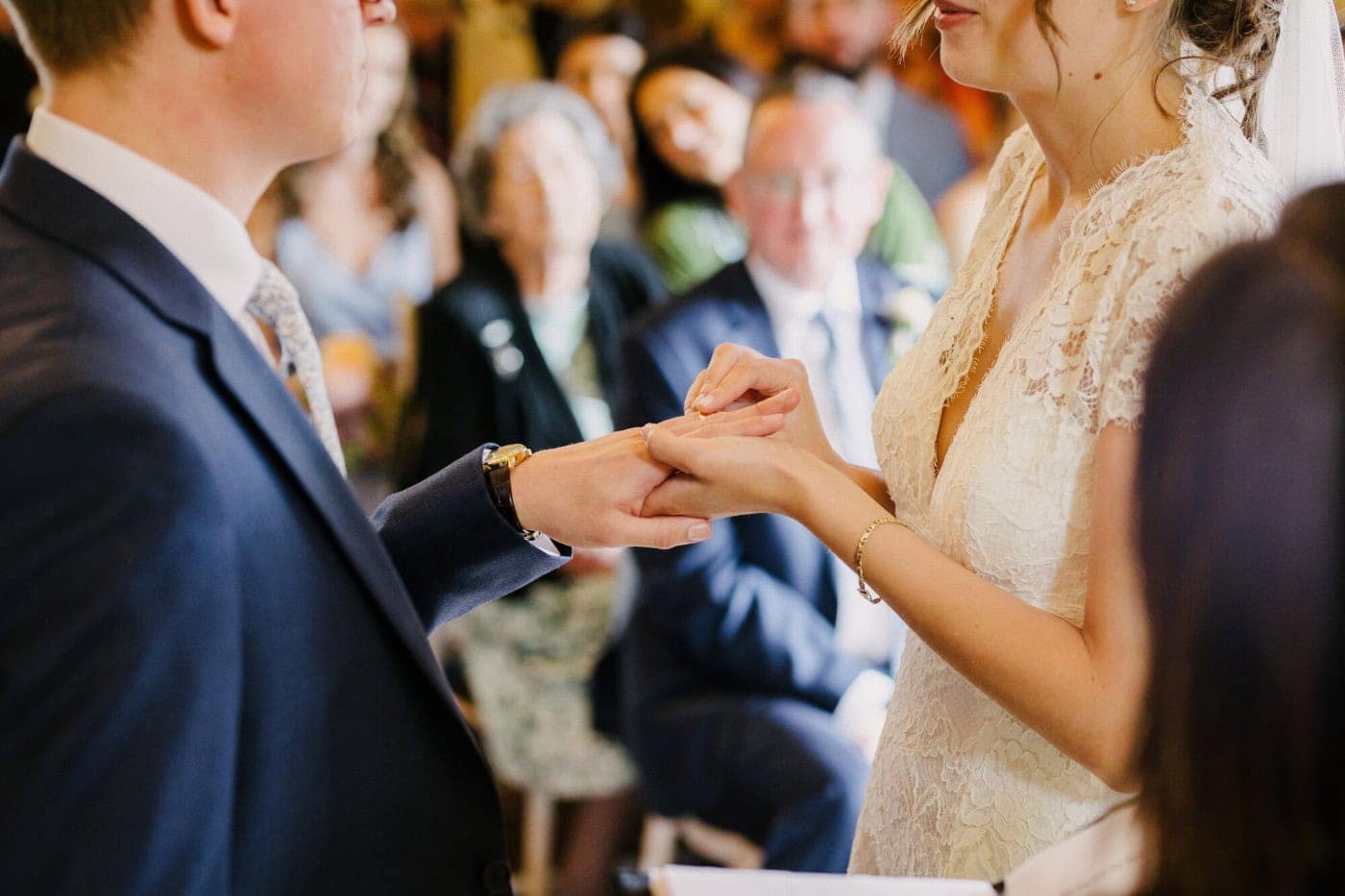 Close up of the exchange of rings during the ceremony in the stone barn