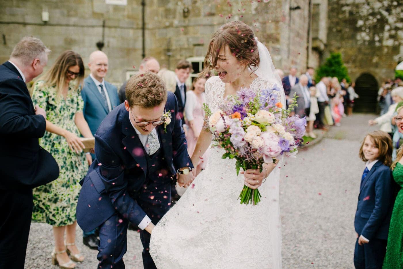 George laughing in the confetti with Ellie outside the ruins of Danby Castle