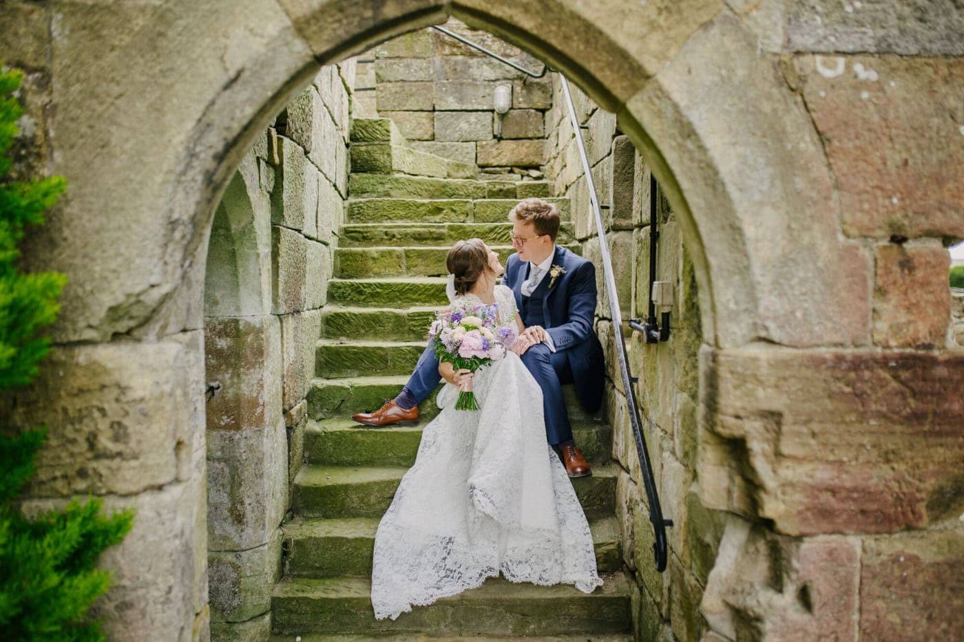Ellie and George on the arched stone staircase at Danby Castle during their couple photos
