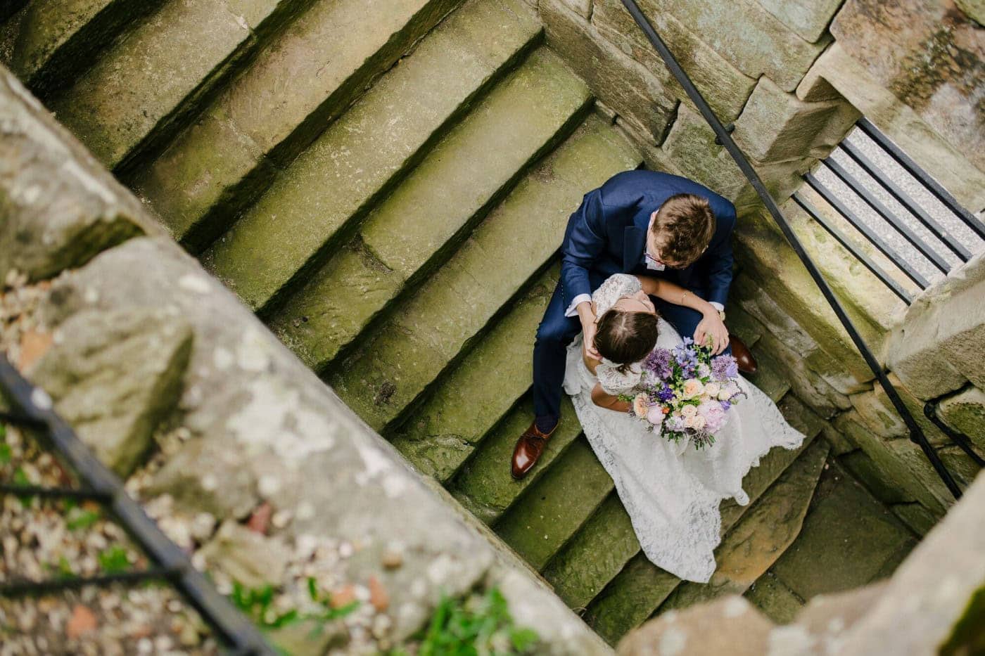 Overhead view of Ellie and George on the worn stone steps of the castle