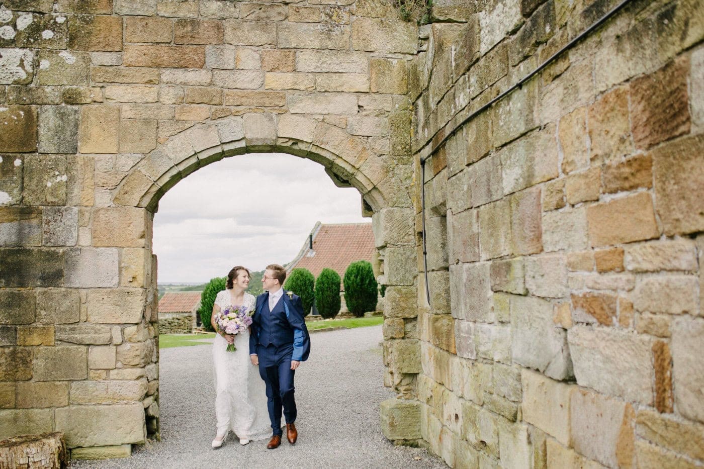 Ellie and George framed by a stone archway at Danby Castle