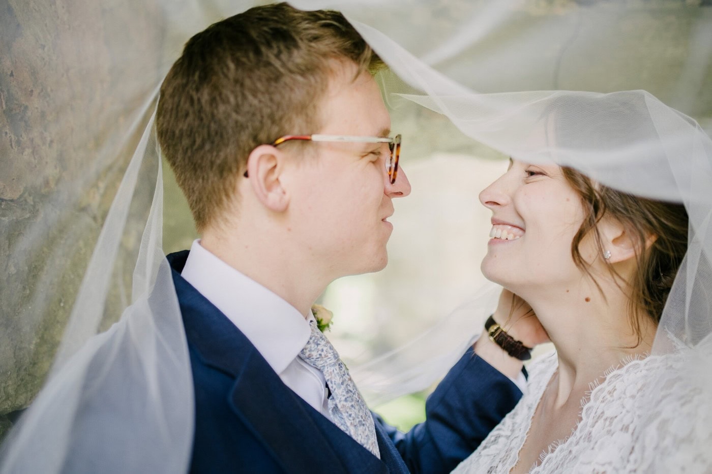 Ellie and George sharing a quiet moment under her veil in the Danby Castle ruins