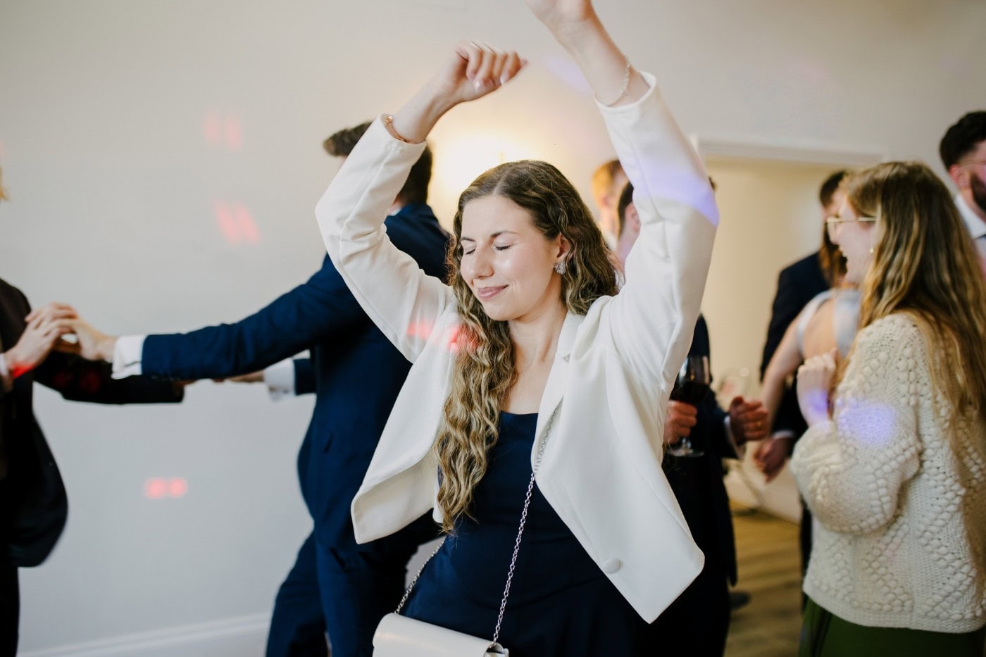Guest dancing with her arms in the air on the dance floor