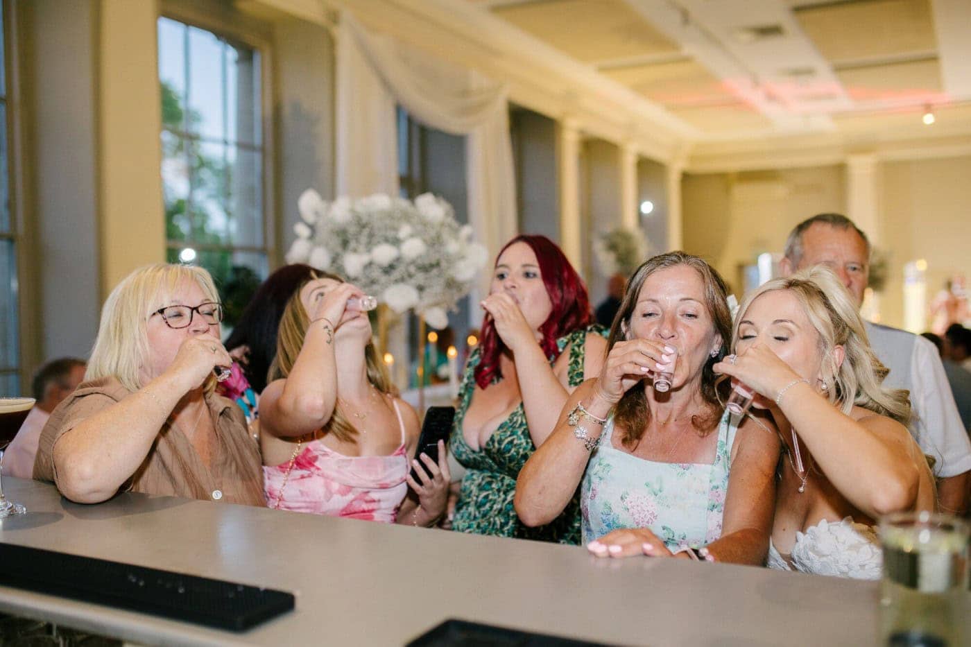 Guests doing shots at the bar during the evening reception at Stubton Hall